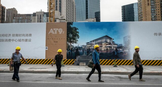 Des ouvriers du bâtiment devant un projet immobilier en construction à Pékin.
