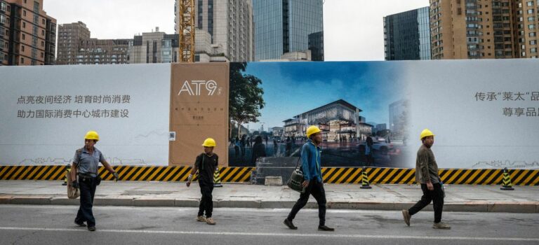 Des ouvriers du bâtiment devant un projet immobilier en construction à Pékin.