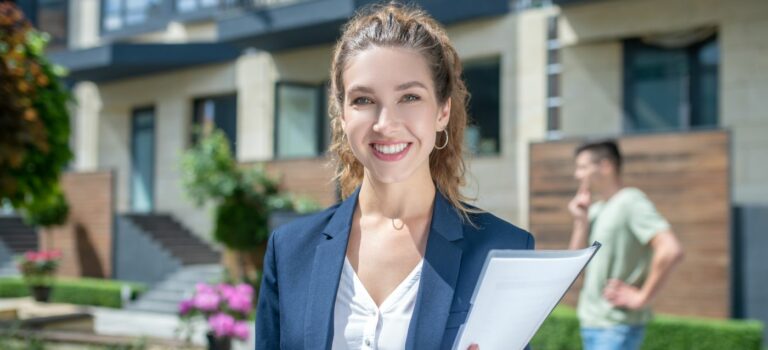 femme agent immobilier devant une maison