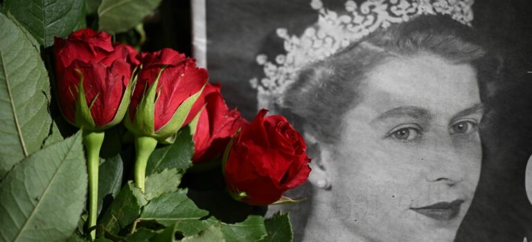 Bouquet de rose posé sur un portrait en noir et blanc d'Elizabeth II