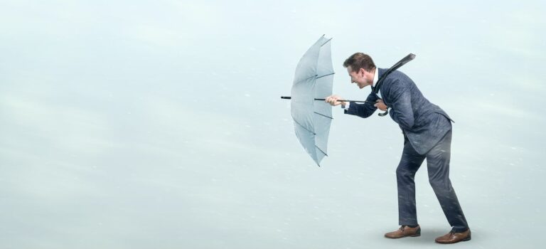 Un homme résiste au vent avec son parapluie