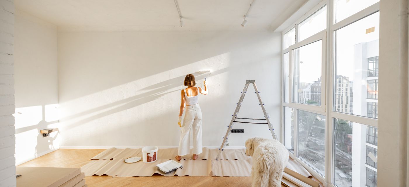 Jeune femme en train de peindre les murs de son appartement