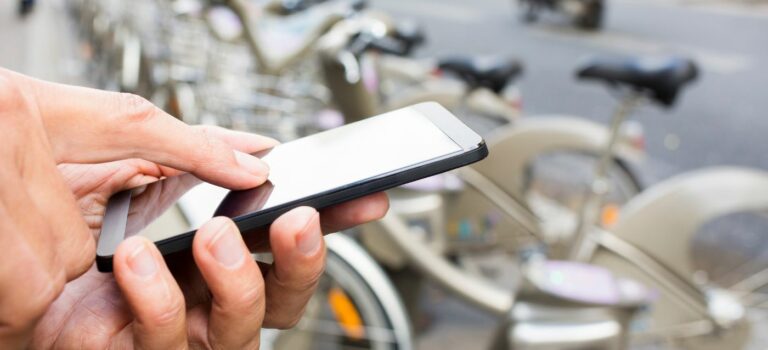 Main avec un teléphone en train de réserver un velib