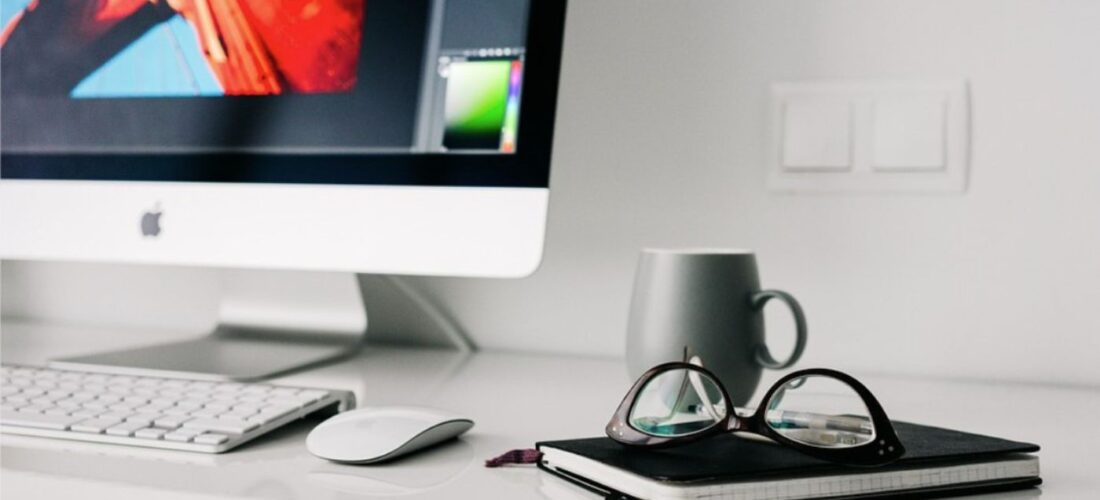 Espace de travail maison avec ordinateur, café, lunettes, cahier