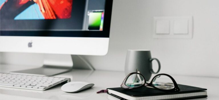 Espace de travail maison avec ordinateur, café, lunettes, cahier