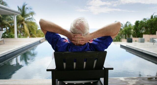 Un homme âgé se prélasse au bord d'une piscine
