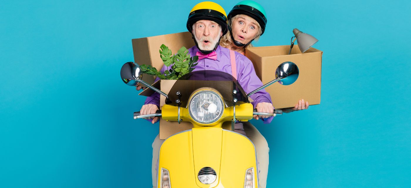 Couple senior avec des cartons sur un scooter