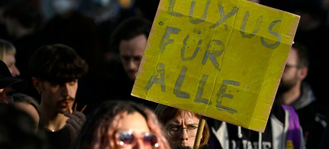 Manifestants à Berlin avec une banderolle Luxus fur alle