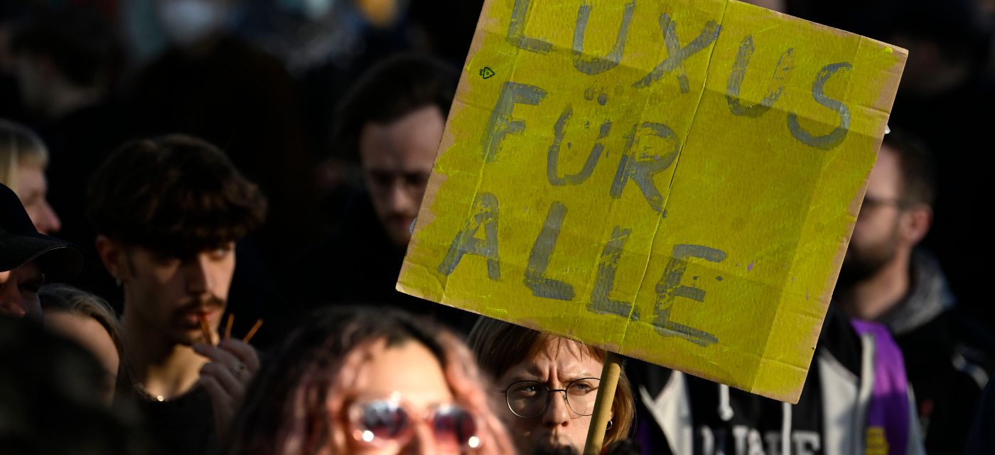 Manifestants à Berlin avec une banderolle Luxus fur alle