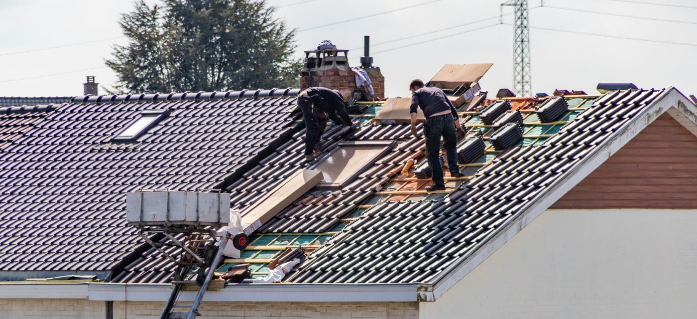 artisans en train d'effectuer des travaux d'isolation sur le toit d'une maison