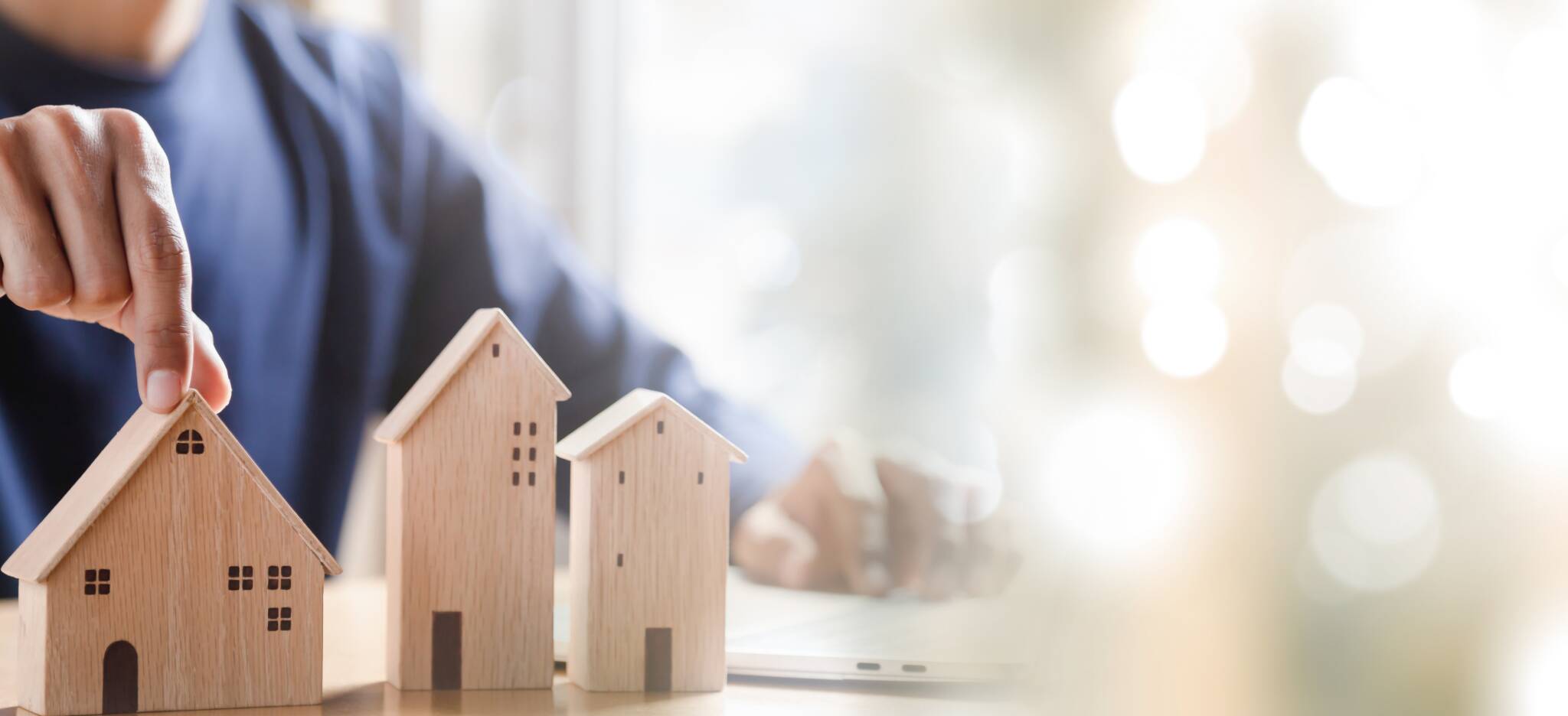 Homme choisissant une maison miniature en bois