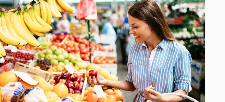 Jeune femme achetant des fruits au marché