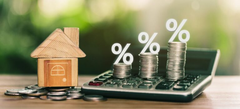 une petite maison, une calculette, des euros et des pourcentages à la hausse