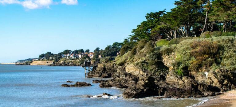 mer, plage, rocher et constructions en arrière plan