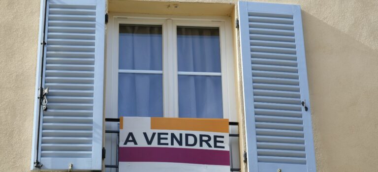 panneau à vendre à la fenêtre d'un immeuble