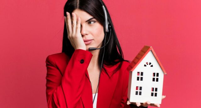 Jeune femme avec une maison miniature dans la main