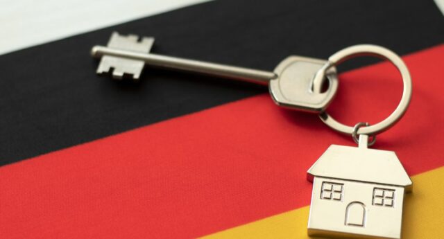 porte clé avec un bien immobilier en allemagne posé sur un drapeau allemand