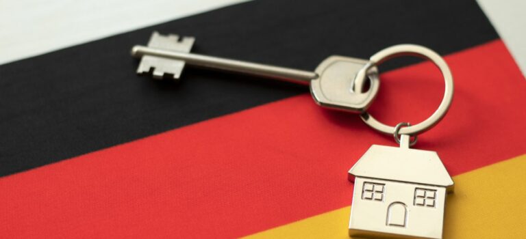 porte clé avec un bien immobilier en allemagne posé sur un drapeau allemand