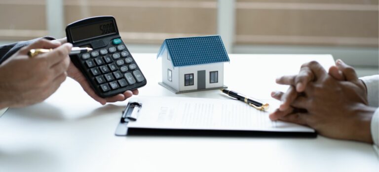 Gros plan sur un agent immobilier calculatrice a la main montrant l'estimation du prix d'un bien immobilier a un proprietaire vendeur
