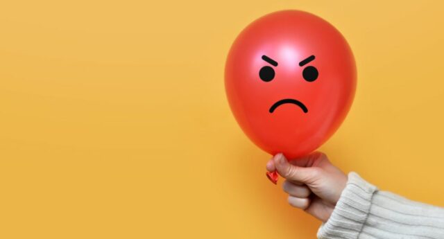 Ballon rouge sur lequel est dessine le visage d'une personne en colere