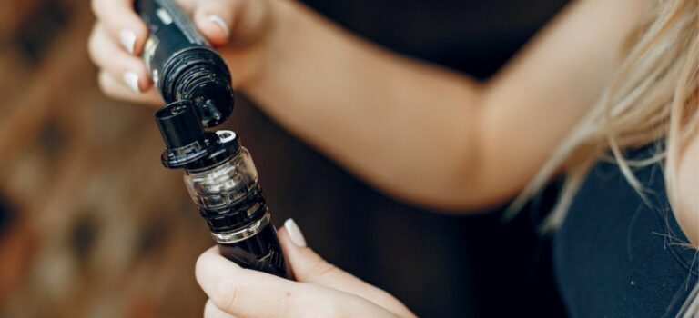 Jeune femme en train de charger sa cigarette electronique