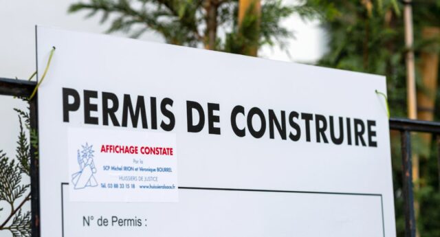 Panneau permis de construire posé sur un chantier