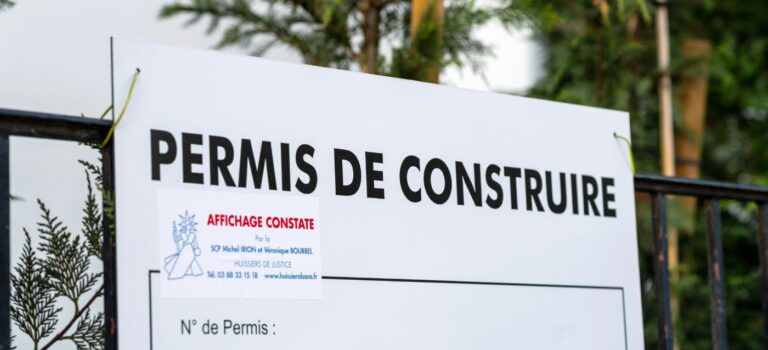 Panneau permis de construire posé sur un chantier