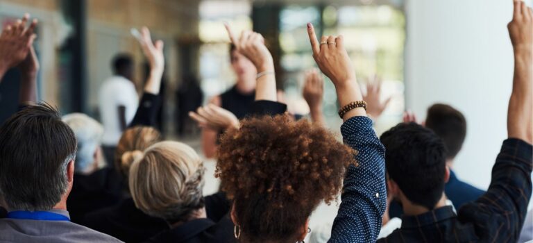 Personnes levant le doigt dans une assemblee generale de copropriete