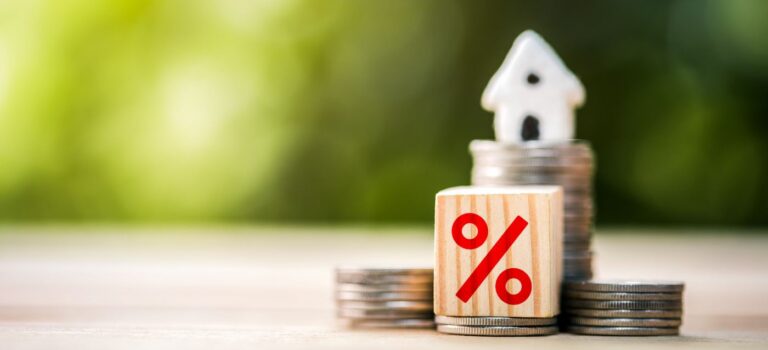 De avec un pourcentages, pieces d'euros avec maison miniature posee dessus pour illustrer le credit immobilier