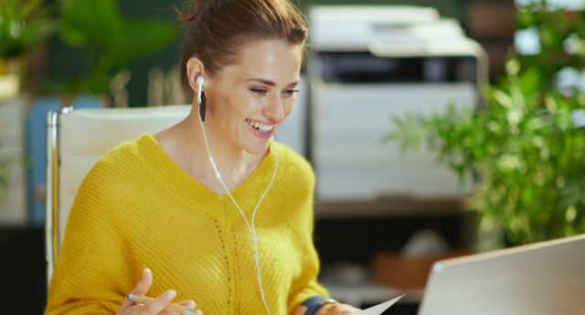 Jeune femme souriante devant son ordinateur