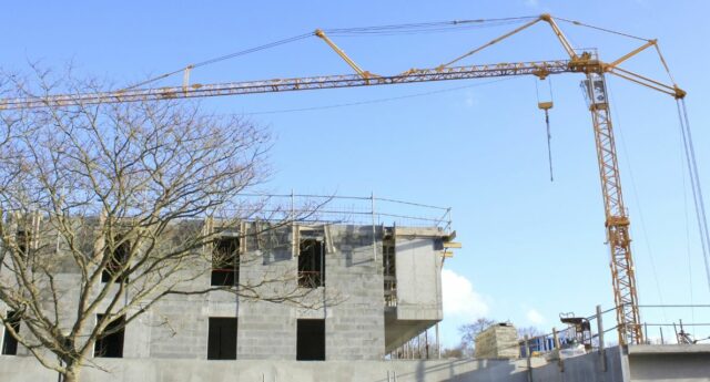 Une grue avec un immeuble en construction en arriere plan pour illustrer l'immobilier neuf