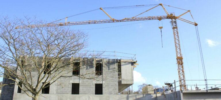 Une grue avec un immeuble en construction en arriere plan pour illustrer l'immobilier neuf