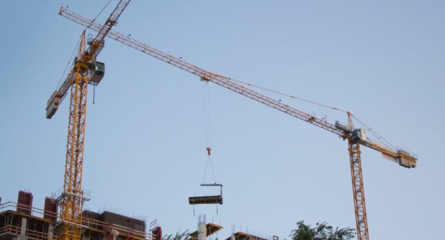 Des grues sur un chantier pour illustrer les permis de construire