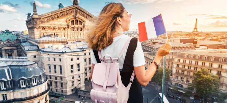 Etudiante avec un drapeau français regardant les immeubles a Paris