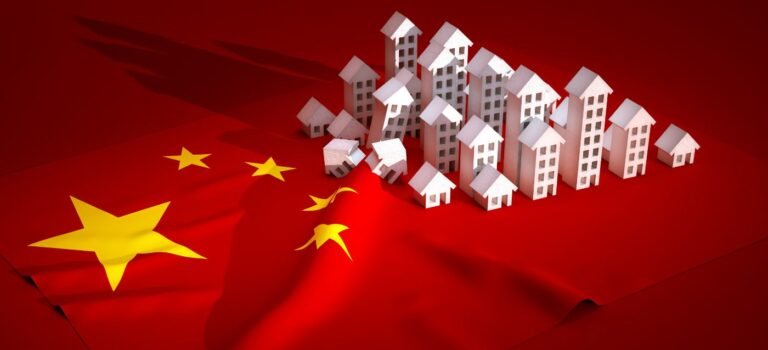 Des immeubles miniatures poses sur un drapeau chinois pour illustrer l'immobilier en Chine