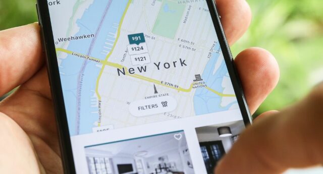 Personne avec un smartphone en main cherchant un logemnet airbnb à New York
