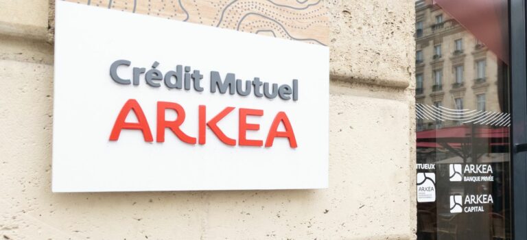 Enseigne Credit Mutuel Arkea posee sur un mur en pierre