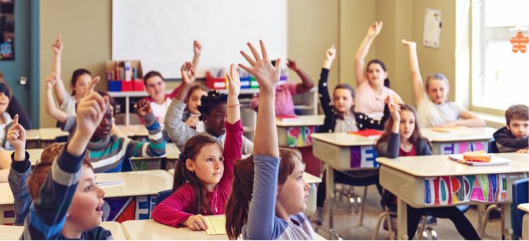 Salle de classe avec des eleves levant la main pour illustrer la rénovation energetique dans les ecoles