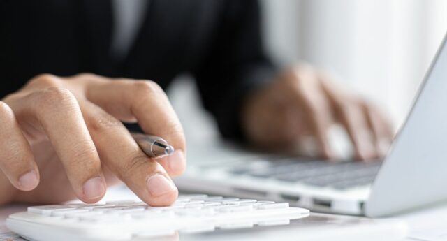 Personne en train de calculer devant son ordinateur