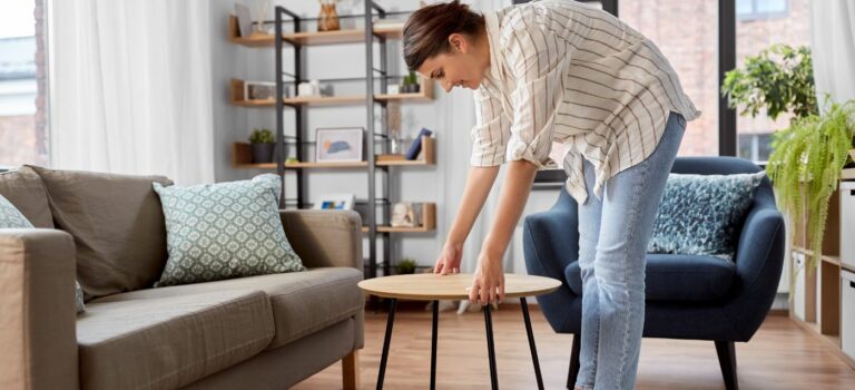 Jeune femme en train de d'installer une table basse dans son salon