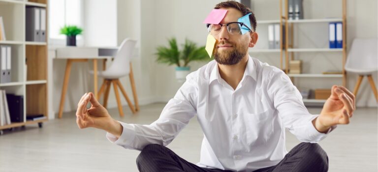 Agent immobilier en tailleur en position de yoga zen avec des post it sur le front