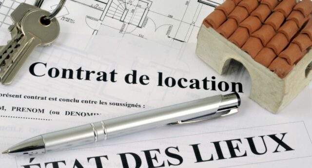 Cles. stylo et maison miniature posée sur n contrat de location et un etat de lieux