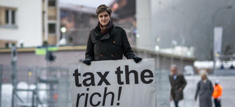 La millionnaire Marlene Engelhorn tenant une pancarte tax the rich
