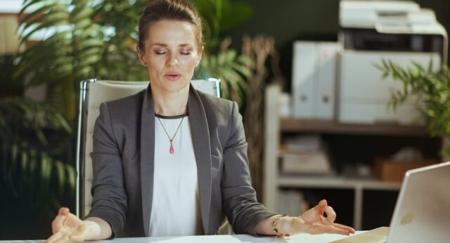 Femme agent immobilier en position zen a son bureau