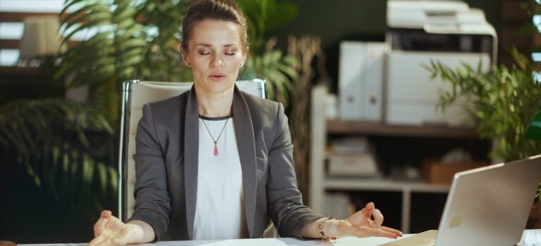 Femme agent immobilier en position zen a son bureau