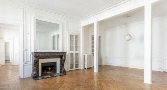 Salon d'un appartement ancien avec parquet, moulures et cheminee