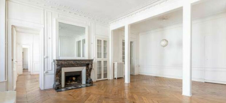 Salon d'un appartement ancien avec parquet, moulures et cheminee