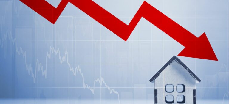 graphique de baisse rouge sur une maison neuve miniature pour illustrer la crise de l'immobilier