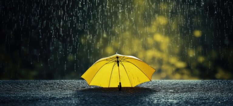 Parapluie jaune poses sur le sol sous la pluie pour illustrer la crise de l'immobilier