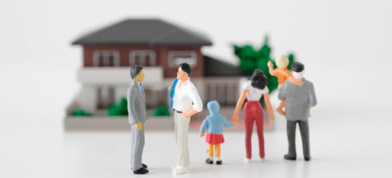 Figurines representant une famille et un agent immobilier devant une maison